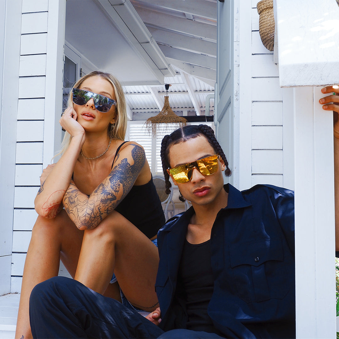 CANNON BALL Polarised Orange Mirrored Shield Sunglasses made of recycled plastic on male model sitting next to someone