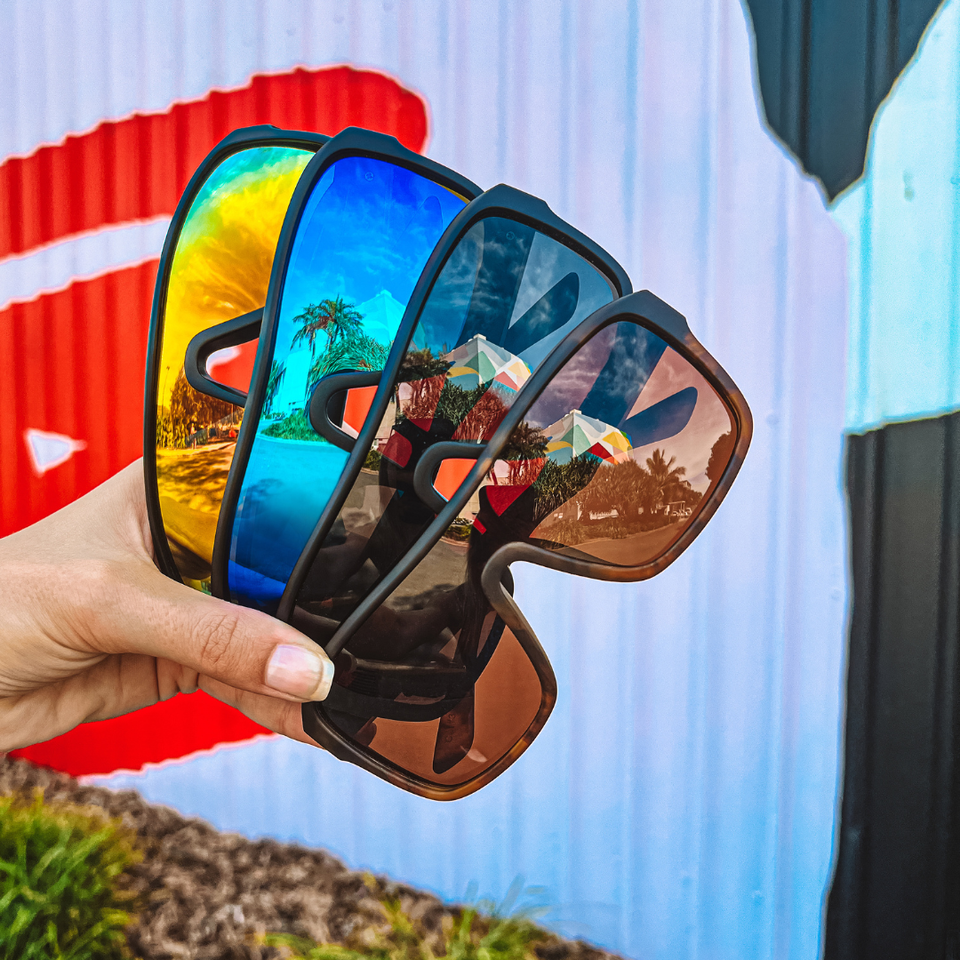 JACKPOT Polarised Blue Shield Sunglasses held by a female model along with other colours