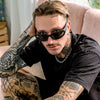 Reefer Polarised Black Wrap Around Sunglasses made of recycled plastic on male model with tattoos