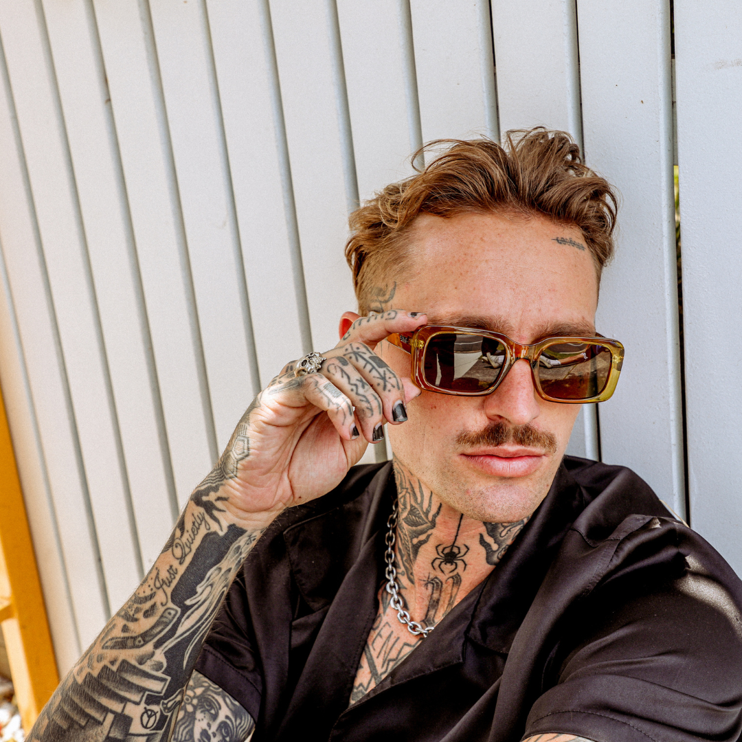 Rocker Polarised Green Rectangle Sunglasses on a male model holding sunglasses in his hand