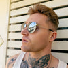 Male model with tattoos wearing a pair of Maverick - Silver Silver sunglasses while looking to his right