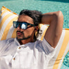 Vespa II Recycled Square Sunglasses with Black Frame and Silver Matte lens on a male model in pool chair