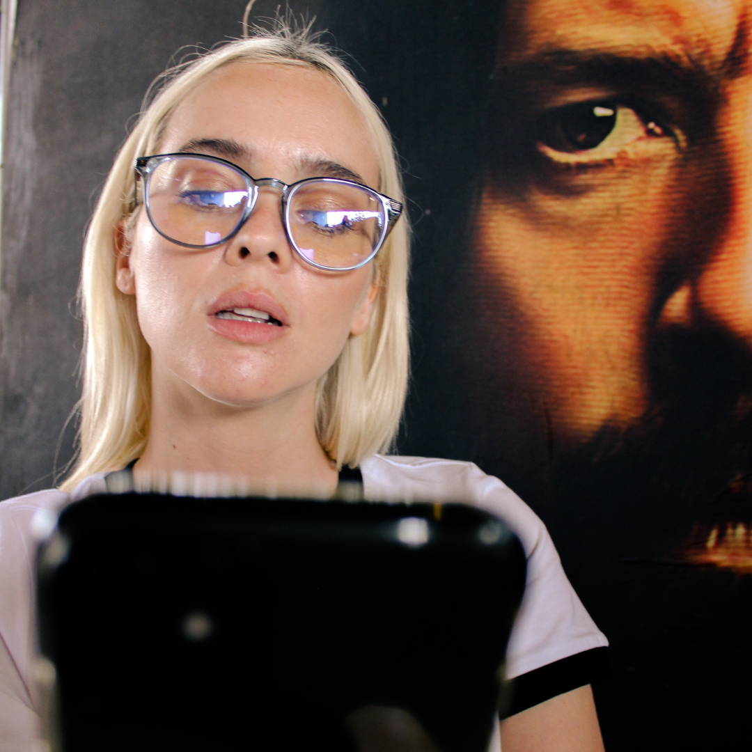 Love Child Blue Round Blue Light Glasses on a female model looking at her phone
