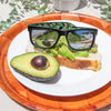 Riot Polarised Matt Black Rectangle Sunglasses with Silver Lens on a plate of avocado