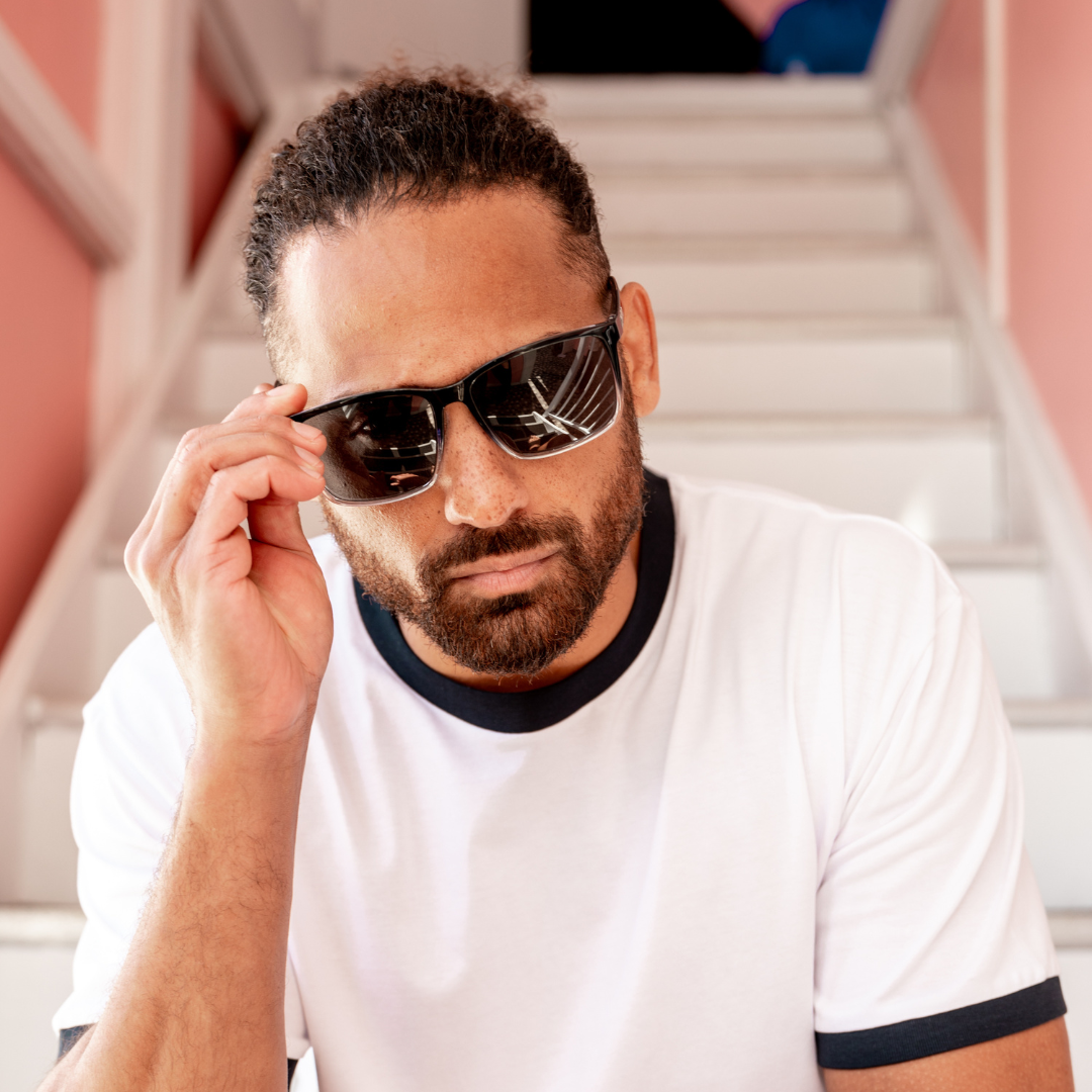 Skylark Polarised Black Rectangle Sunglasses on a male model sitting on stairs