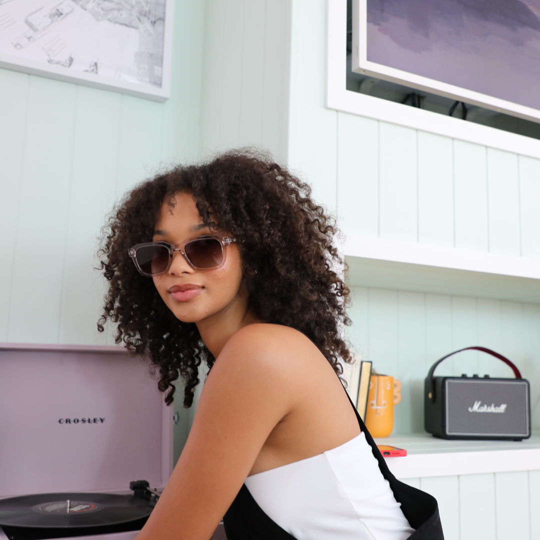 Chiller Polarised Grey Square Sunglasses on a female model next to a record player