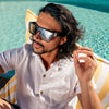 LOOSE CANNON Polarised Silver Shield Square Sunglasses on a male model sitting on a pool chair