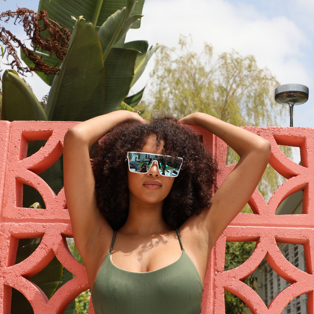 LOOSE CANNON Polarised White Shield Square Sunglasses with Blue Mirrored Lens on a female model against a wall