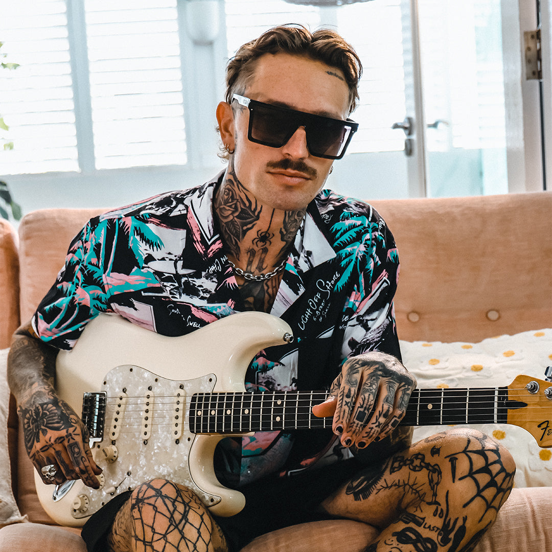 THE BAR Polarised Black Square Sunglasses on a male model playing the guitar