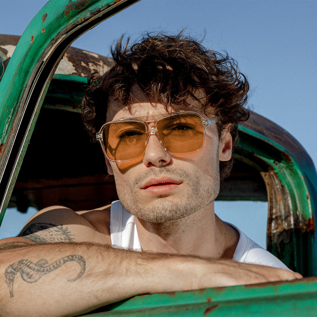 The Duke Crystal Sand Brown worn by male model in green car