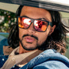 Vespa II Recycled Square Sunglasses with Black Frame and Red Matte lens on a male model in a classic car