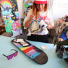 LOOSE CANNON Polarised Shield Square Sunglasses with Black Frame and Pink Mirrored Lens next to a skateboard and CRT artist