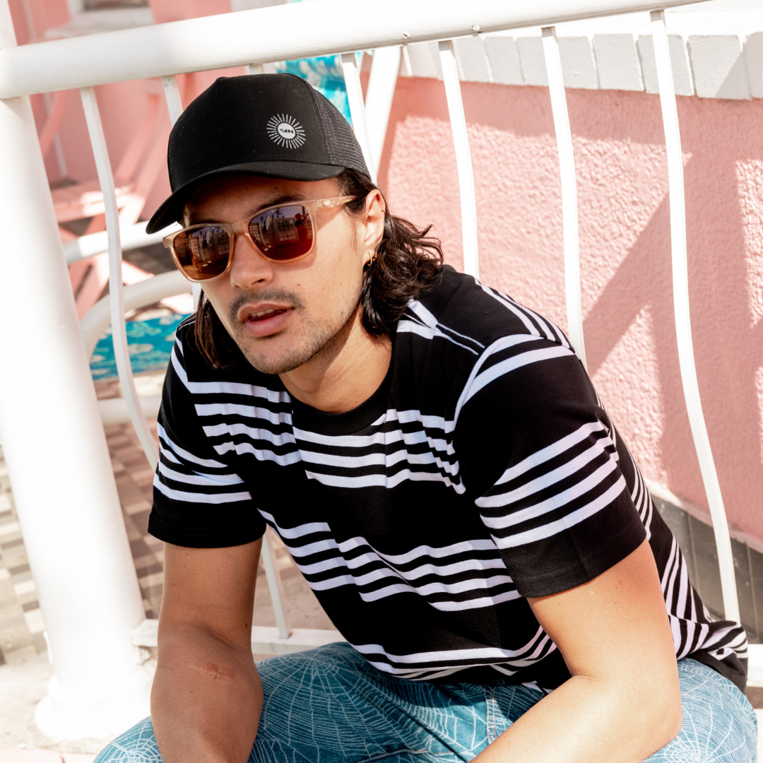 SIN Adjustable Black Cap on male model sitting on a bench