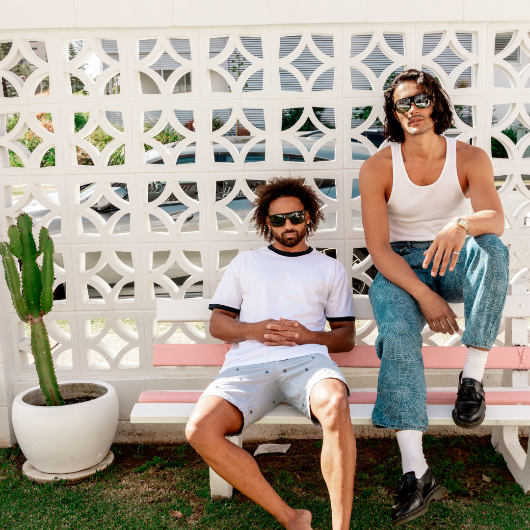 UNDERTOW Polarised Black and Grey Square Sunglasses on a male model sitting on a bench